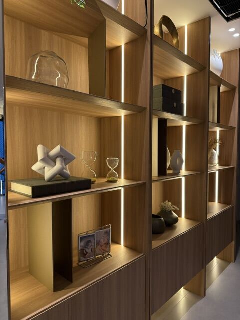 Estante decorada com esculturas, vasos e objetos iluminados
